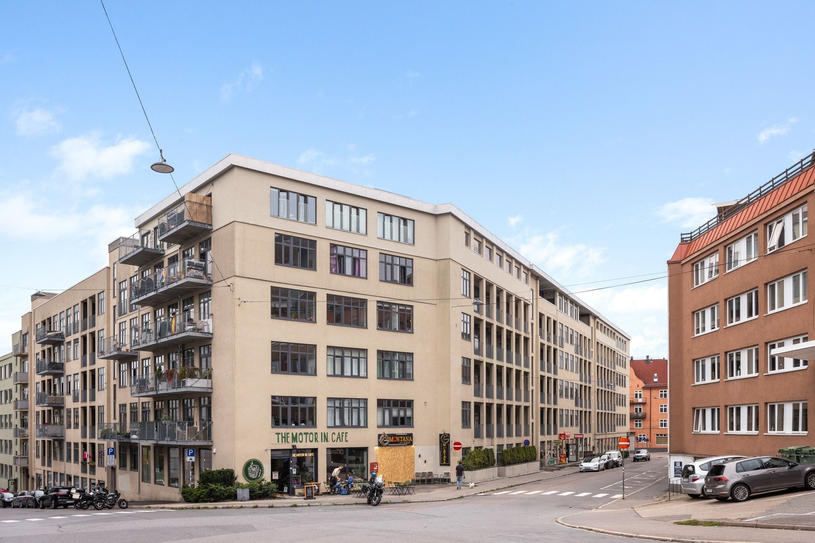 Nordøstlig fasade med inngangsparti i rolig enveiskjørt gate. Til venstre i bilde ligger innkjørsel til sameiets garasje med heis opp til leiligheten. Galleribilde