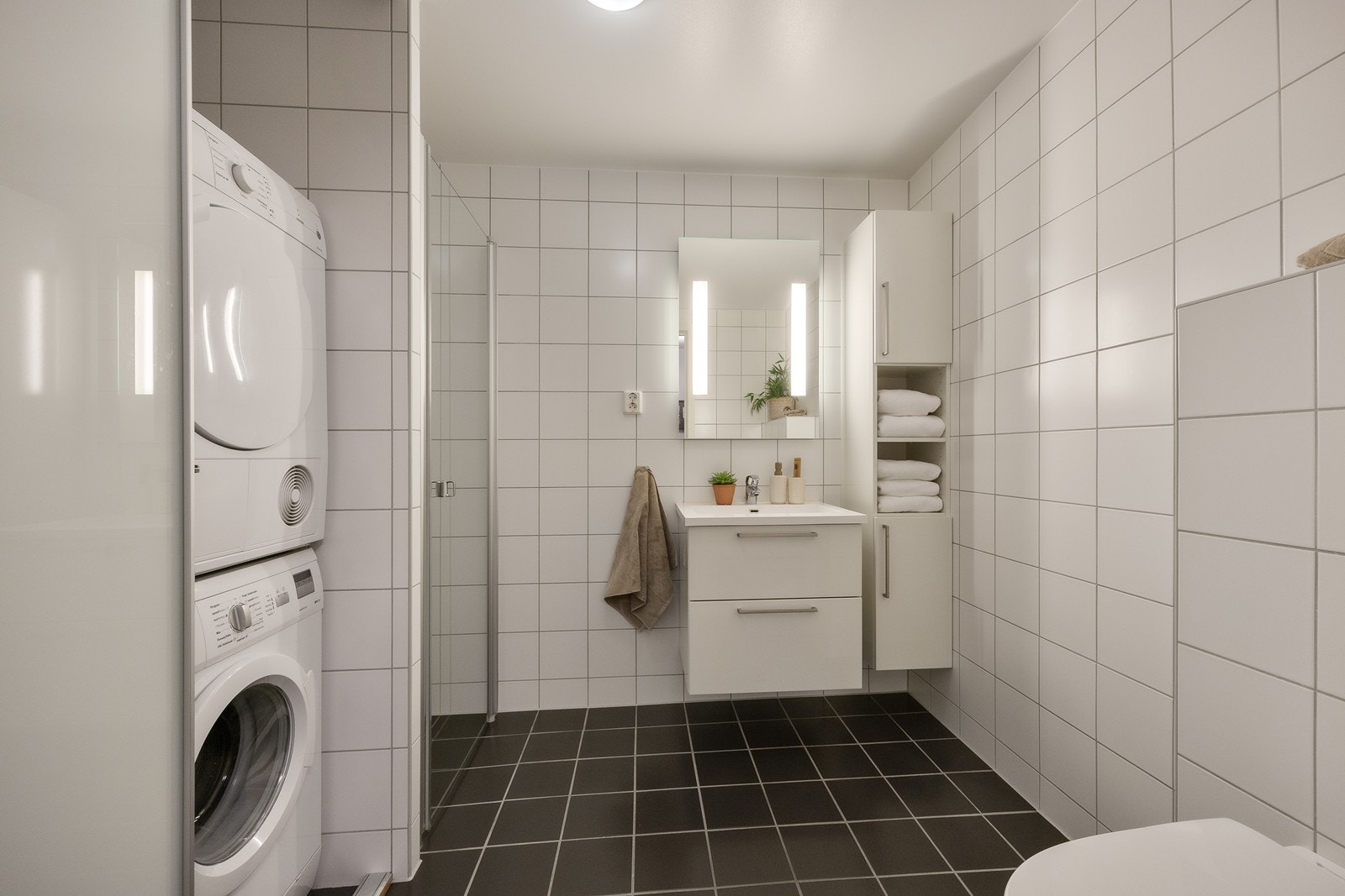 Baderommet er smart utformet med nisje for dusj, samt skyvedører foran avsatt plass til vaskemaskin og tørketrommel. Galleribilde