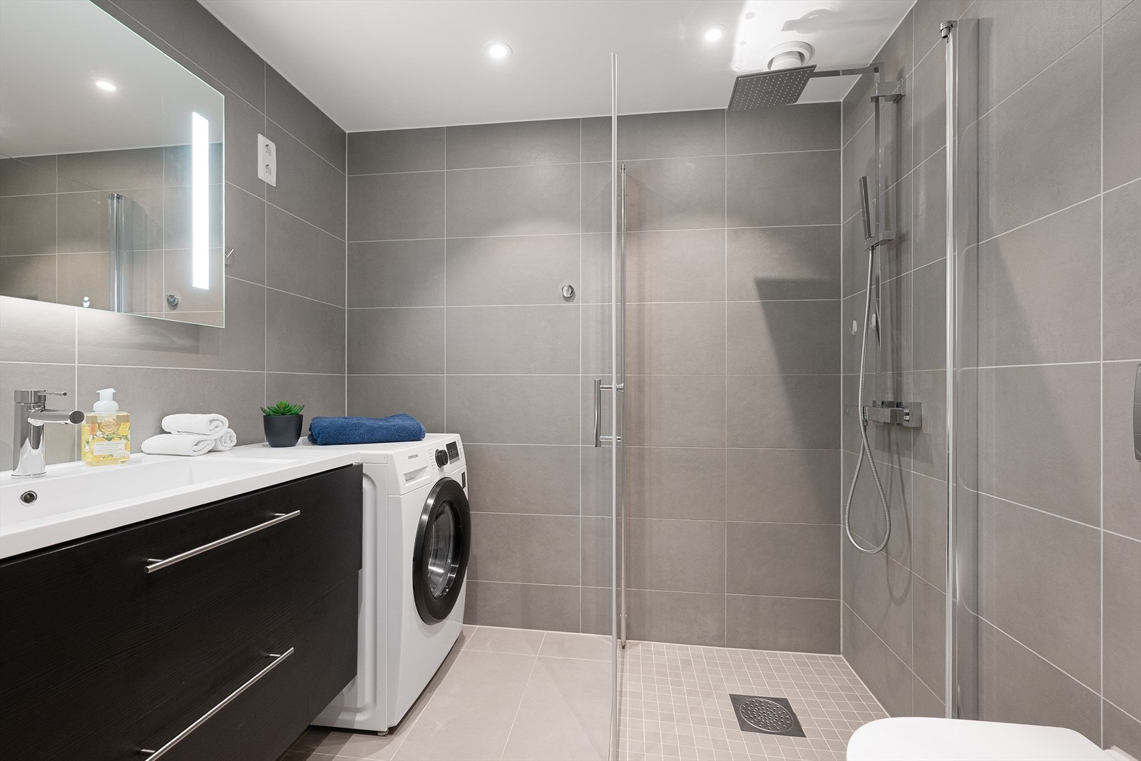 Lekkert flislagt med dusjhørne og plass til vaskemaskin Galleribilde