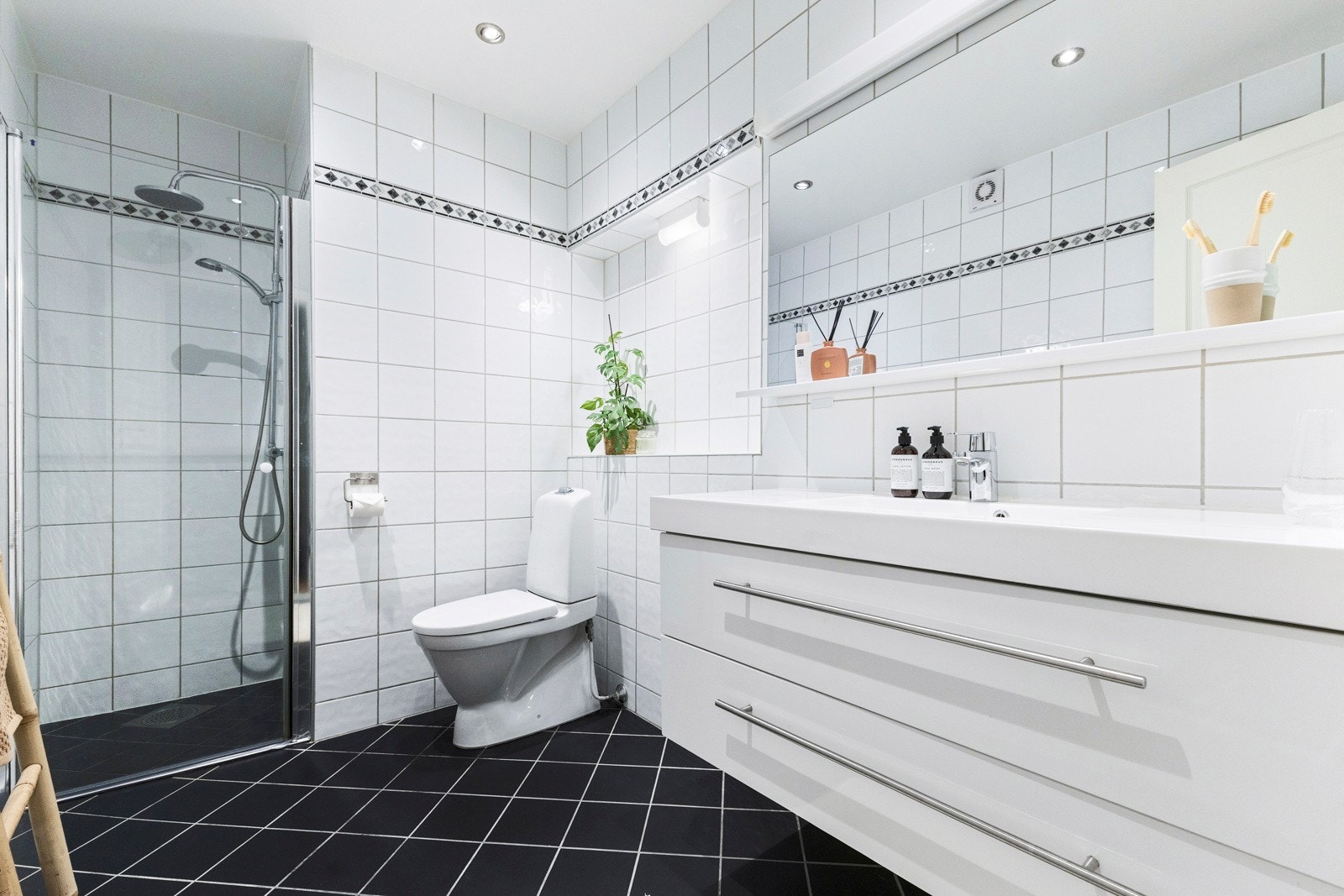 Badet i 1 etasje fremstår stilrent og funksjonelt, med en enkel og gjennomført utforming Galleribilde