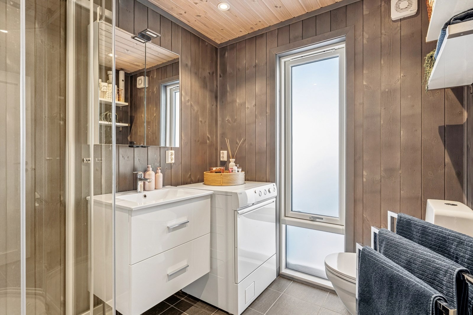 Badet er delikat og funksjonelt, med flislagt gulv og gulvvarme, panelplater på veggene og panel i himlingen. Galleribilde