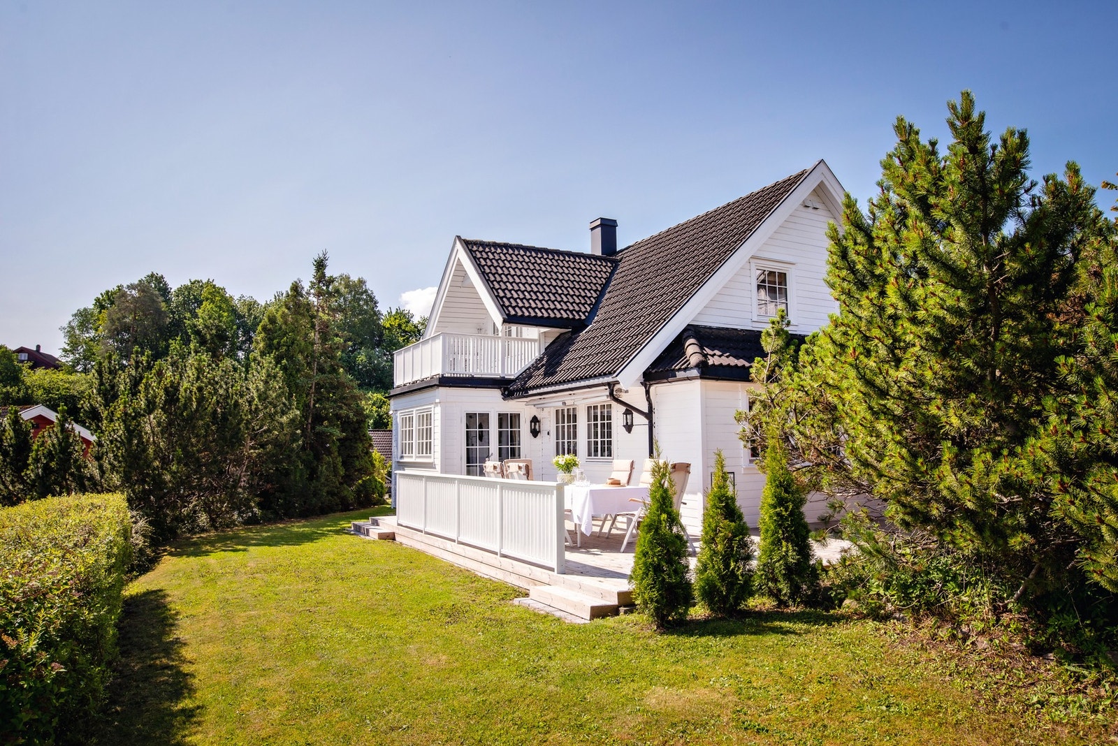 Bilde tatt fra i sommer. Hagen er pent opparbeidet med gressplen og beplantninger. Galleribilde