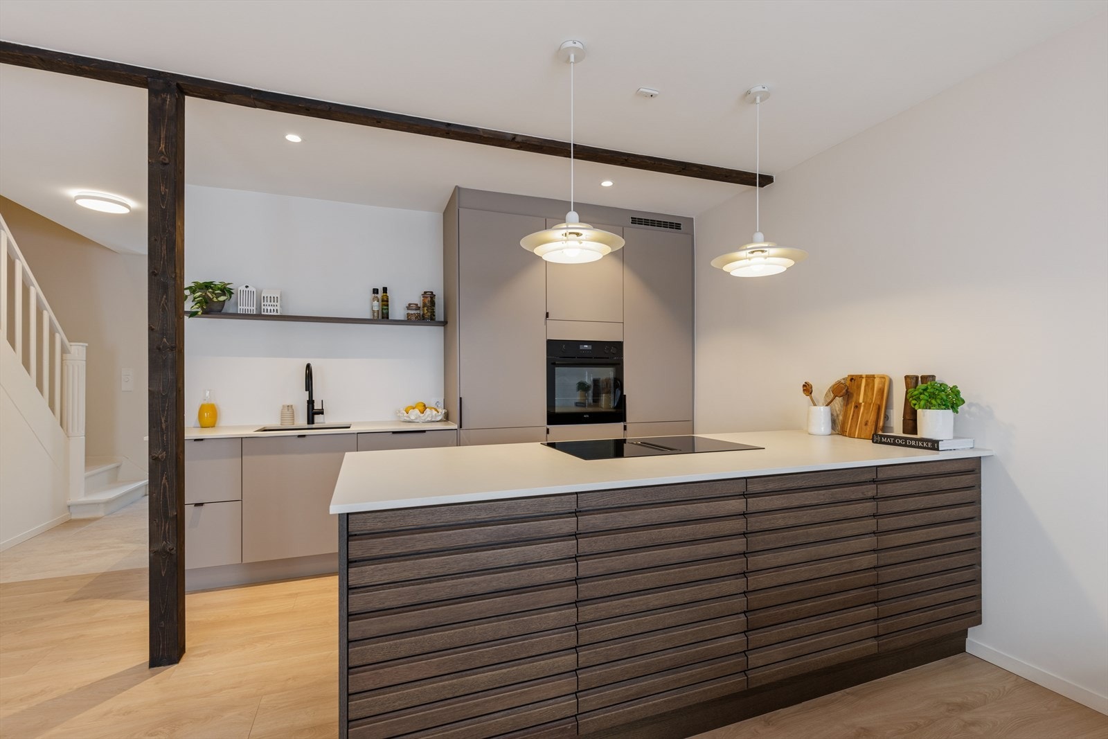 Kjøkkenet er et sosialt midtpunkt med en stilren kjøkkenøy og integrerte hvitevarer. Galleribilde