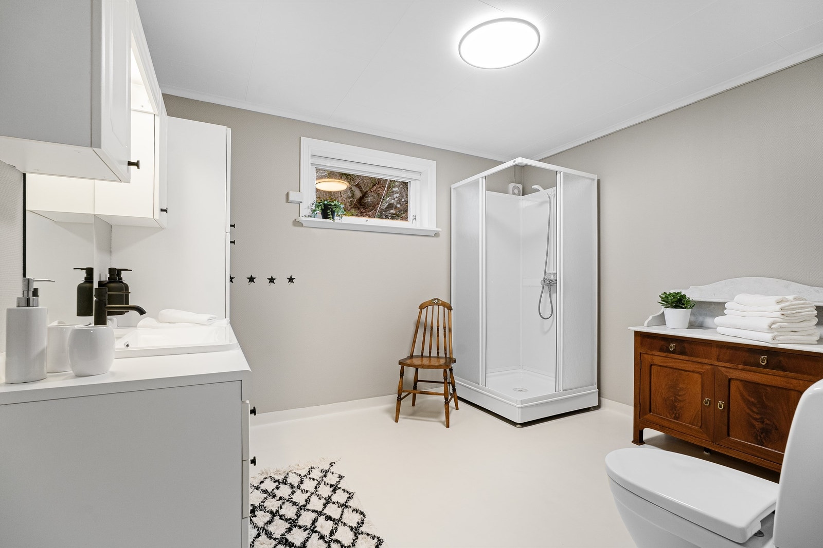 Bad nr. 2 har dusjkabinett, toalett, nyere servant og blandebatteri samt godt med oppbevaringsplass. Det er også opplegg til badekar til høyre i bildet. Galleribilde