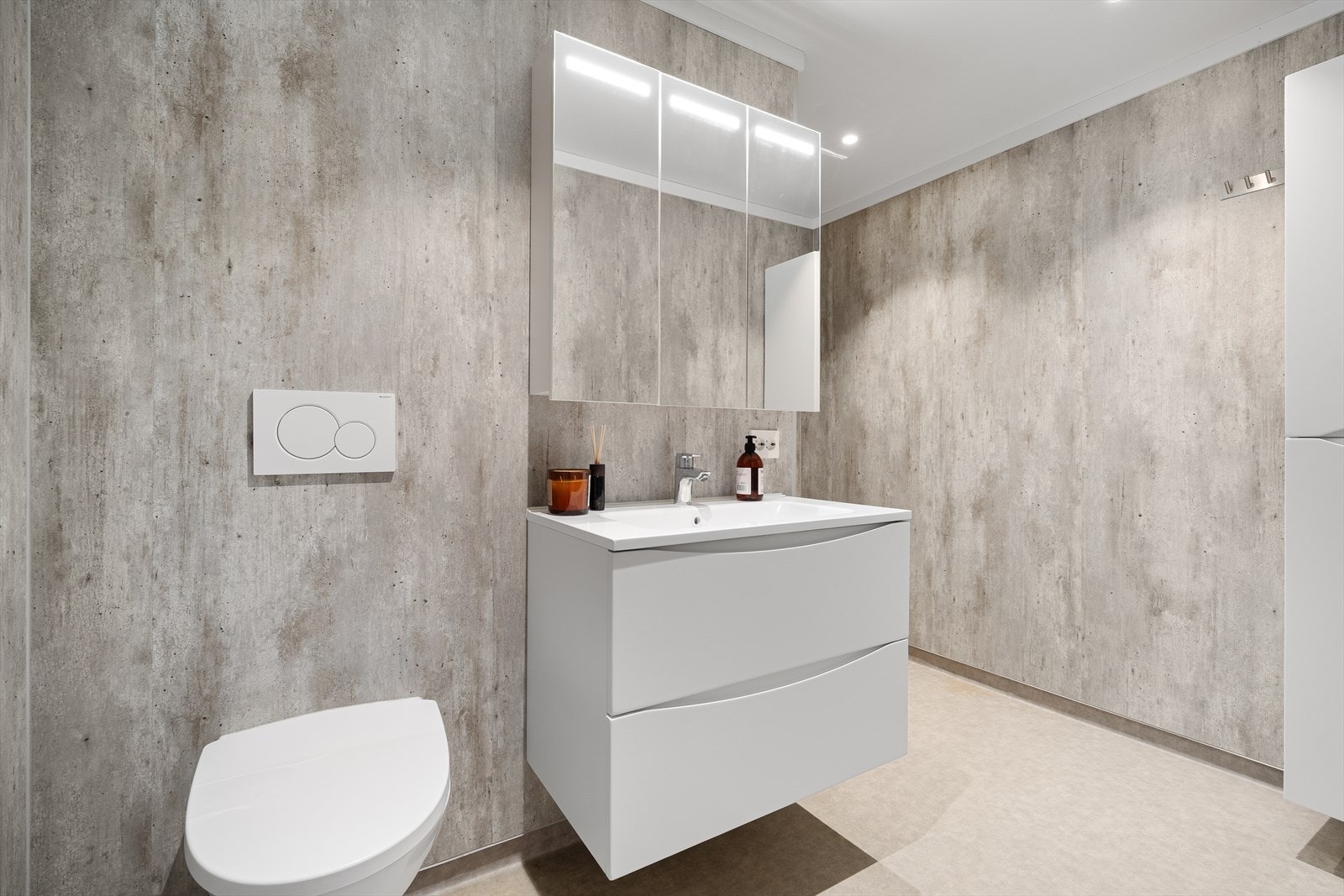 Bad med vegghengt toalett, servant med innredning og dusjnisje Galleribilde