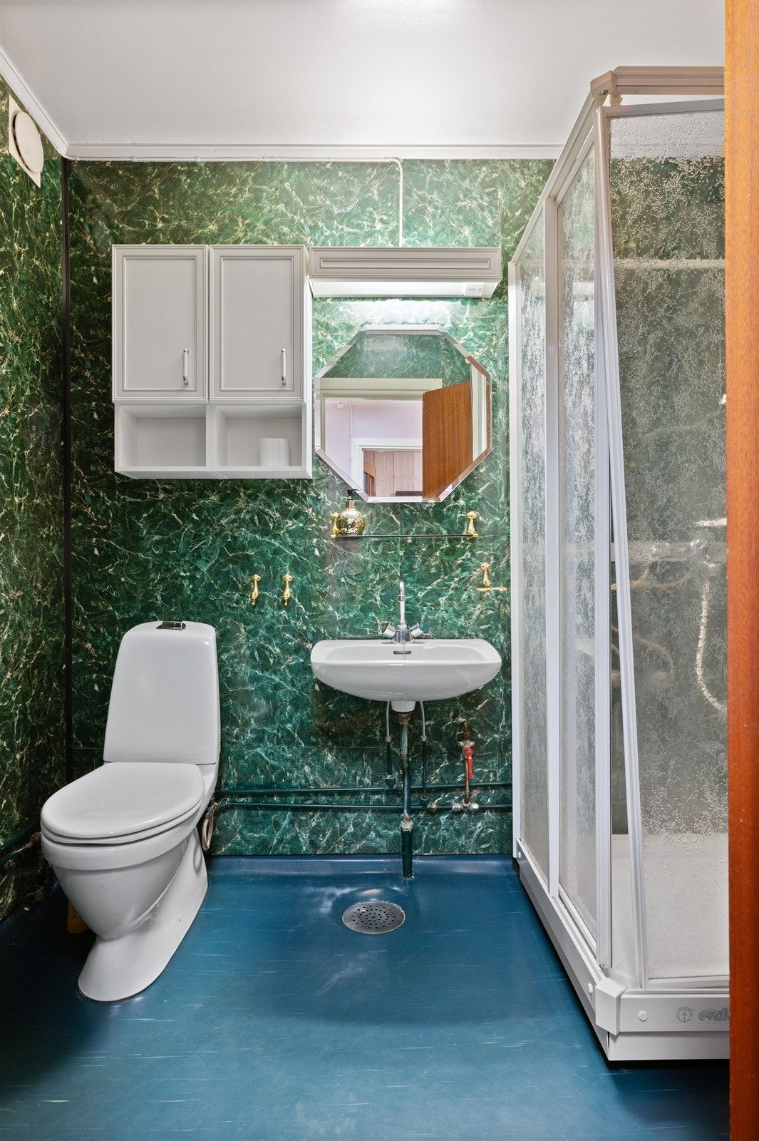 Badet er utstyrt med toalett, servant og et praktisk dusjkabinett. Galleribilde