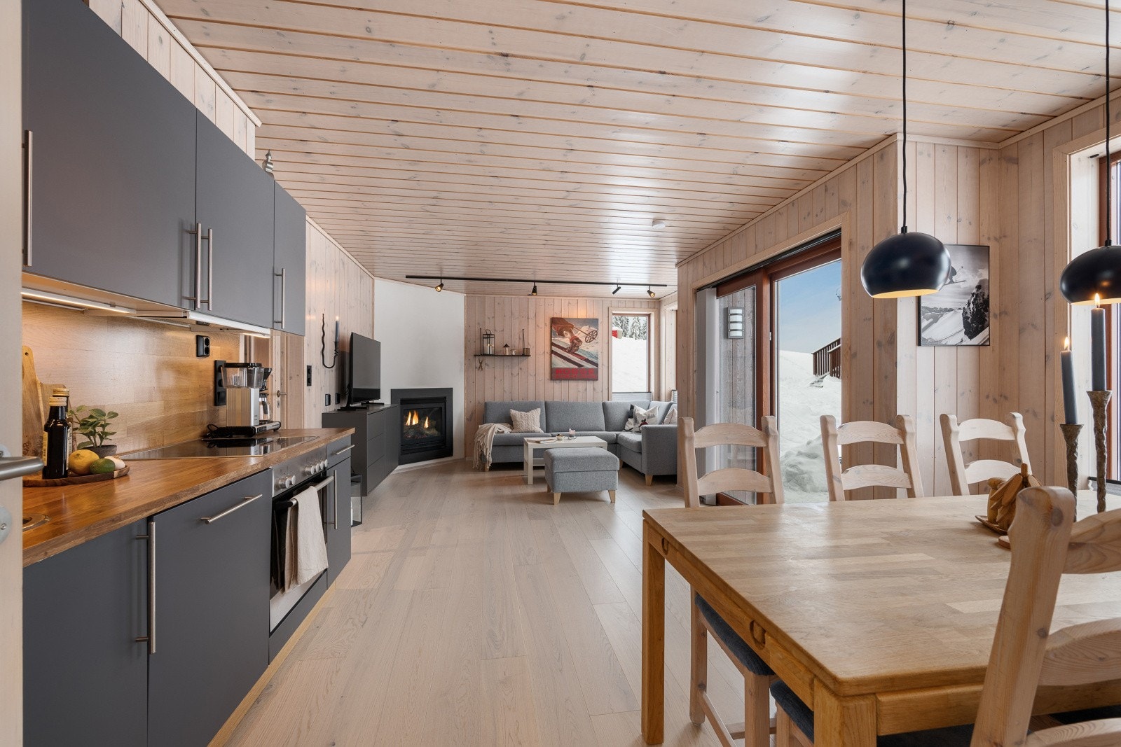 Pen og tidløs kjøkkeninnredning med slette, grå fronter og laminat benkeplate med nedfelt oppvaskkum og platetopp. Galleribilde