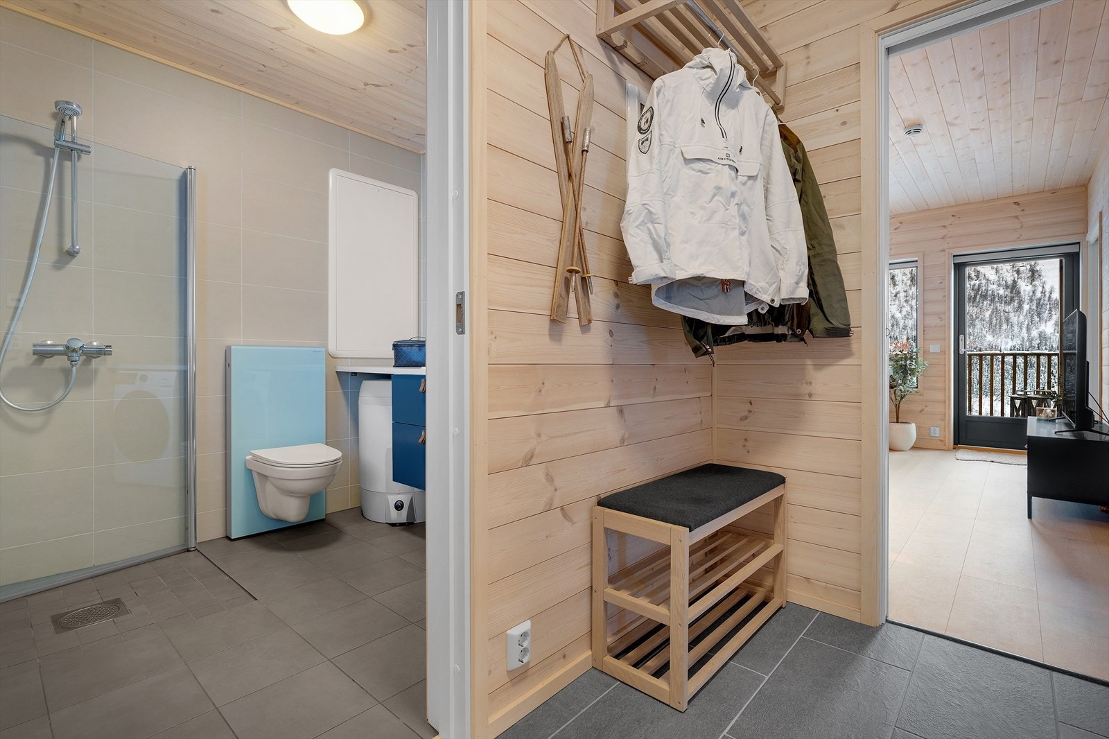 Det er en romslig og lys entré med flislagt gulv med gode oppbevaringsmuligheter Galleribilde