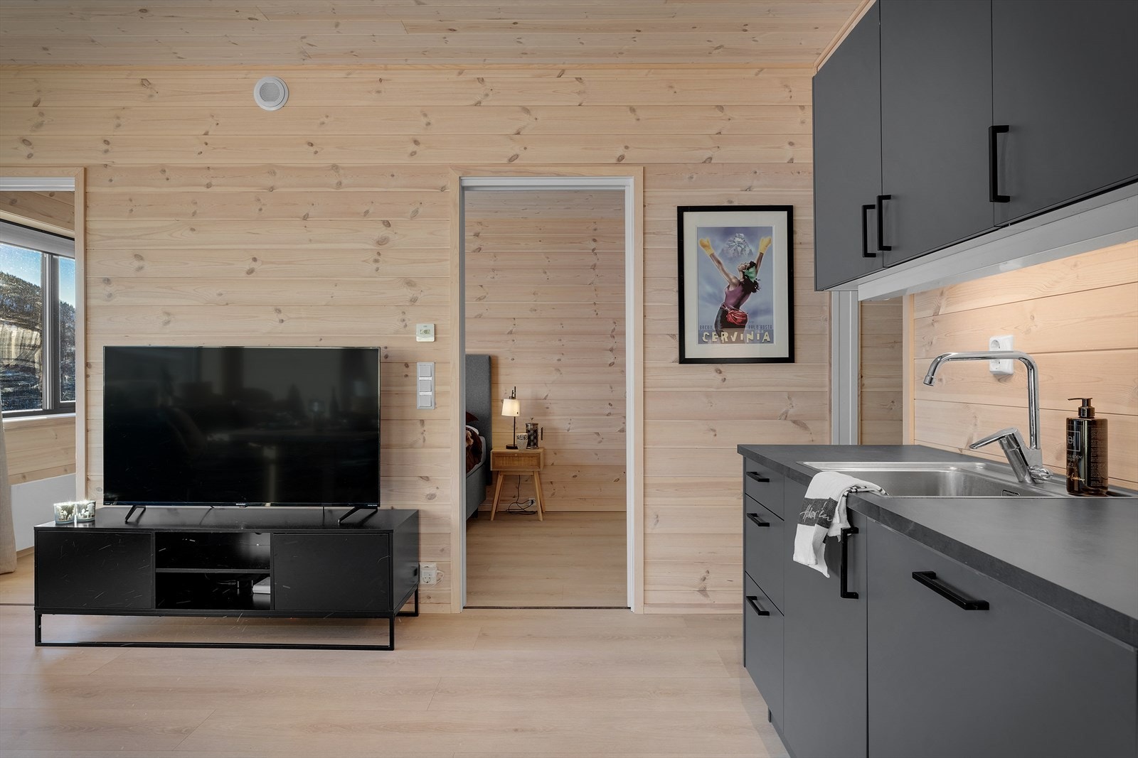 Stuen kan vise til lyse fargevalg som gir den gode "hyttefølelsen" og har naturlige møbleringssoner med stuesone med plass til sofa og TV Galleribilde