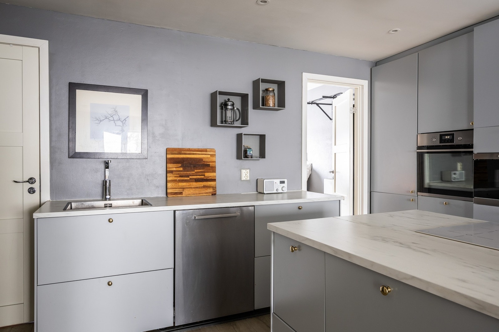 Innredningen har grå glatte fronter og grå benkeplate i laminat. Galleribilde