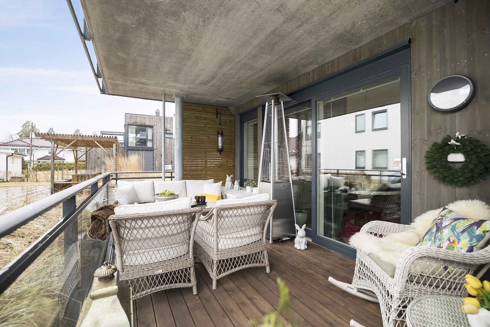 Balkongen til leiligheten i 2.etasje gir et fint overbygg og lun følelse på terrassen Galleribilde