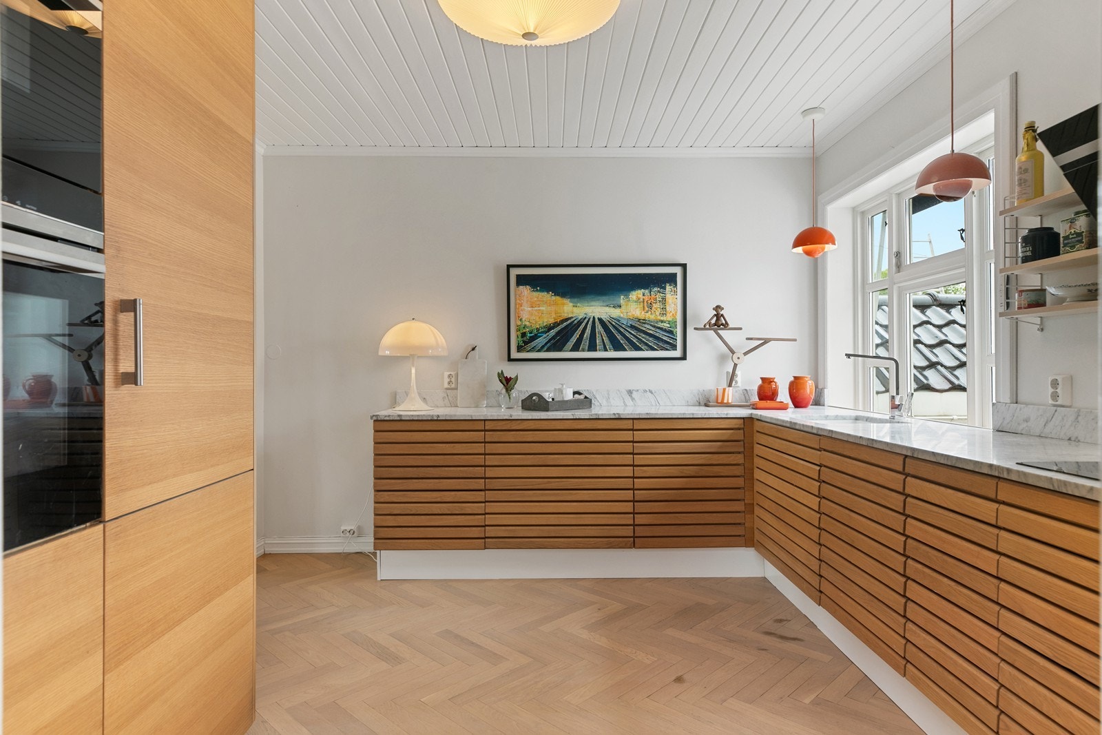 Moderne kjøkken med steinbenkeplate, integrerte hvitevarer og rene linjer. Galleribilde