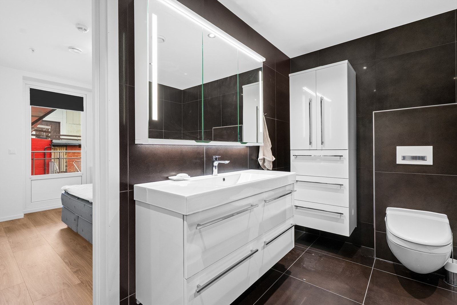 Stilfullt baderom med moderne innredning, doble servantløsninger og rikelig skapplass Galleribilde