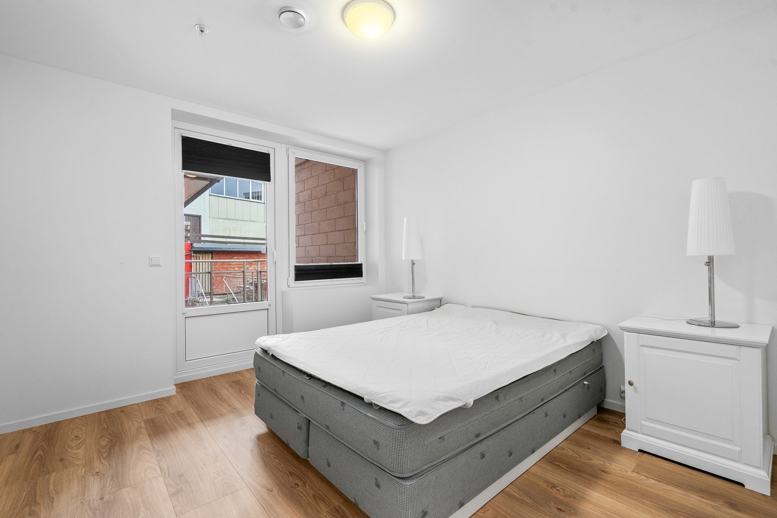 Lyst soverom med god plass til dobbeltseng, garderobeskap og utgang til uteområde i stille bakgård Galleribilde