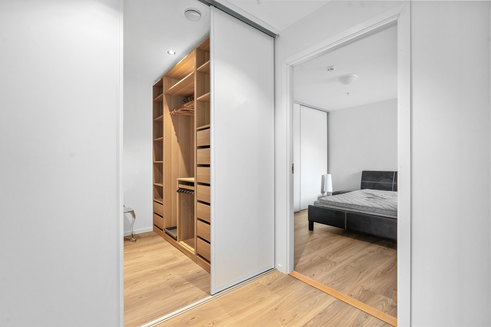 Romslig walk-in garderobe med praktiske oppbevaringsløsninger, tilknyttet soverom. Galleribilde