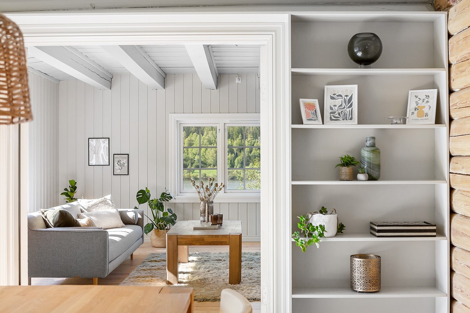 De lyse panelveggene, synlige bjelker og store vinduer slipper inn rikelig med dagslys og fremhever utsikten mot naturen. Galleribilde