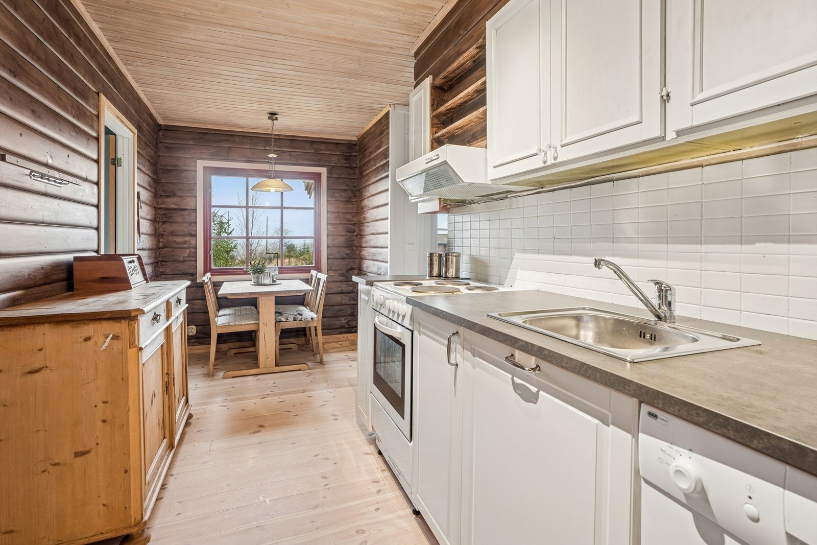 Innredningen har profilerte fronter, laminatbenkeplate og integrert oppvaskmaskin. Galleribilde