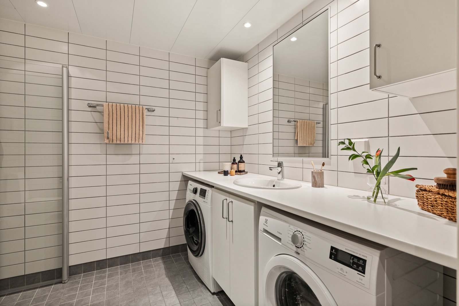 Badet er lyst og delikat. Det er opplegg for vaskemaskin og tørketrommel. Galleribilde