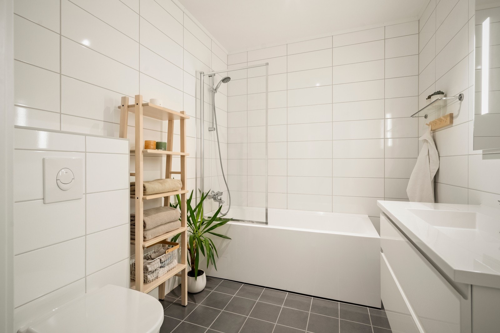 Innredningen består av en servantseksjon, veggmontert toalett og et badekar. Galleribilde