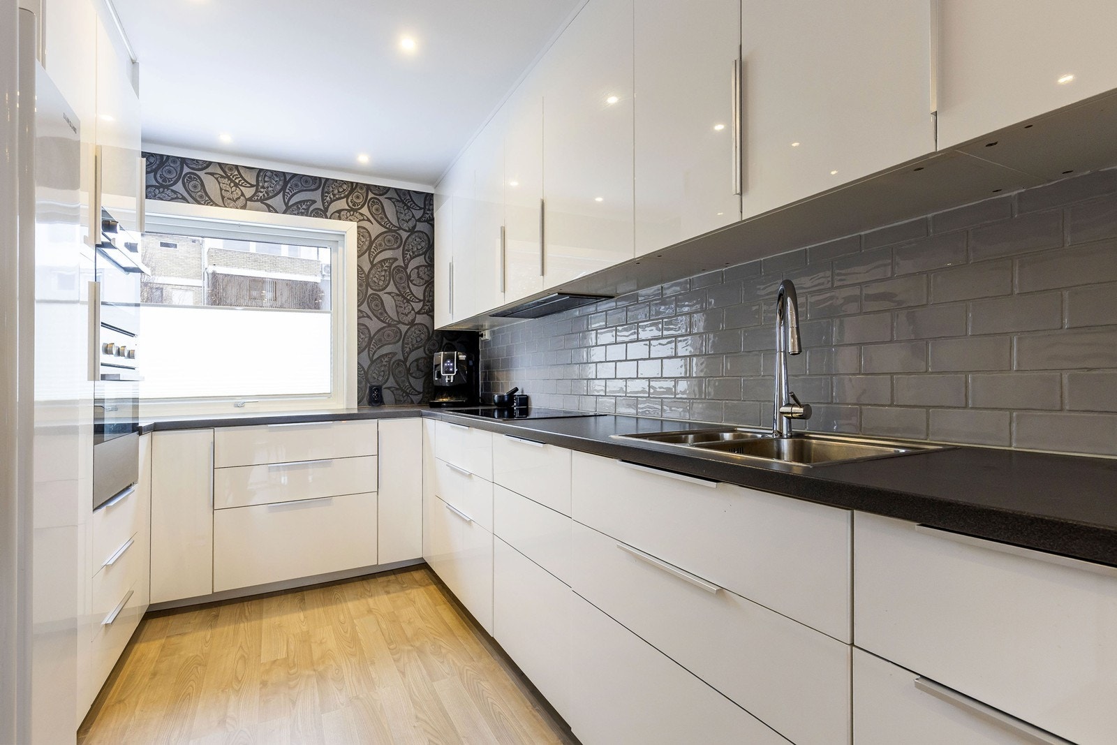 Kjøkkenet har integrerte hvitevarer, bortsett fra kjøleskap som er frittstående Galleribilde