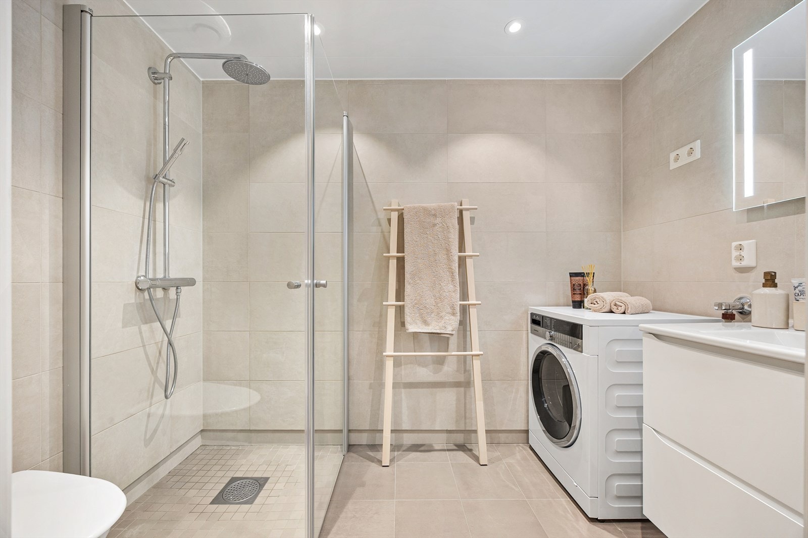 Dagene får en god start på dette stilrene og helflisede badet med en moderne finish. Galleribilde