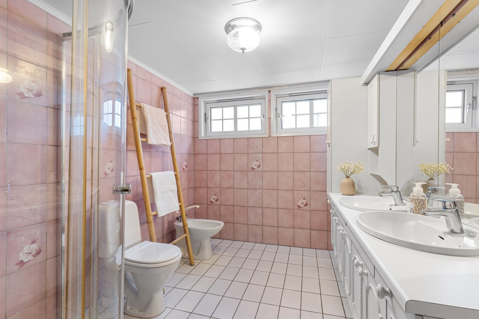 Badet i andre etasje er fra byggeåret og har gulvfliser med varme, samt innredning med to servanter, bidé, toalett og dusjhjørne. Galleribilde