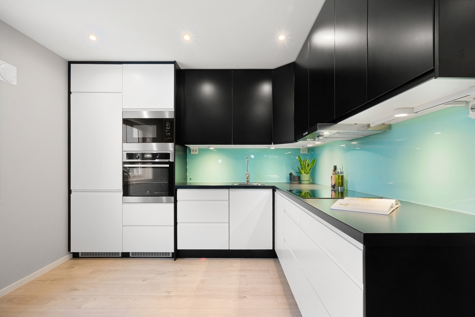 Innredningen har slette fronter, mørk laminatbenkeplate og beskyttelsesplater mellom over- og underskap. Hvitevarer fra Electrolux inkluderer kombiskap kjøl/frys, stekeovn, mikro, platetopp og oppvaskmaskin. Galleribilde