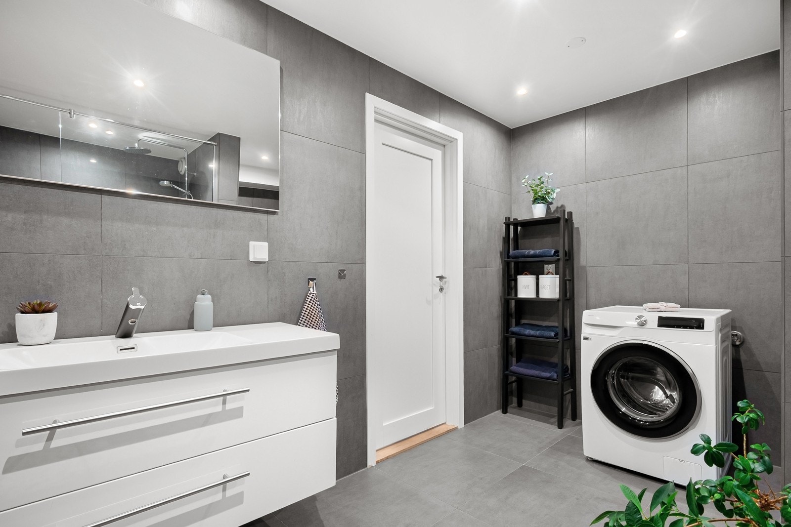 Badet har downlights, gulvvarme og store fliser i 60x60-format. Galleribilde