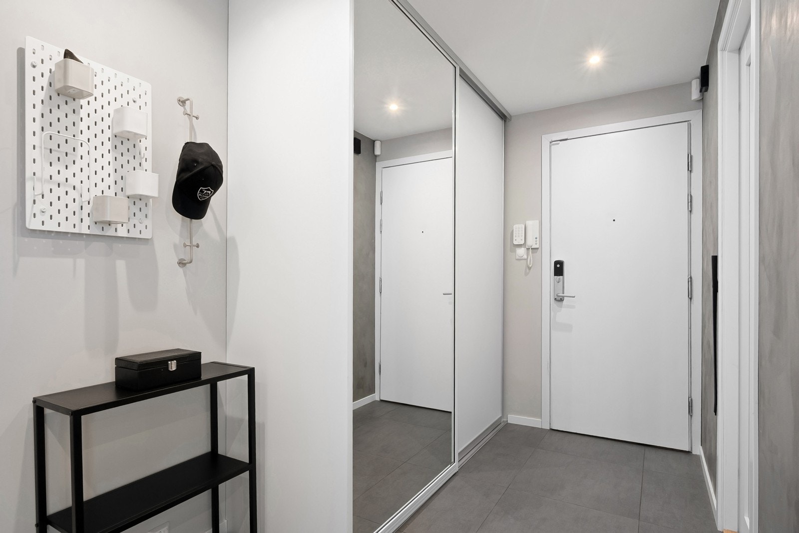 Entréen har flislagt gulv og praktisk skyvedørsgarderobe med speilfronter som gir god oppbevaringsplass for yttertøy. Galleribilde