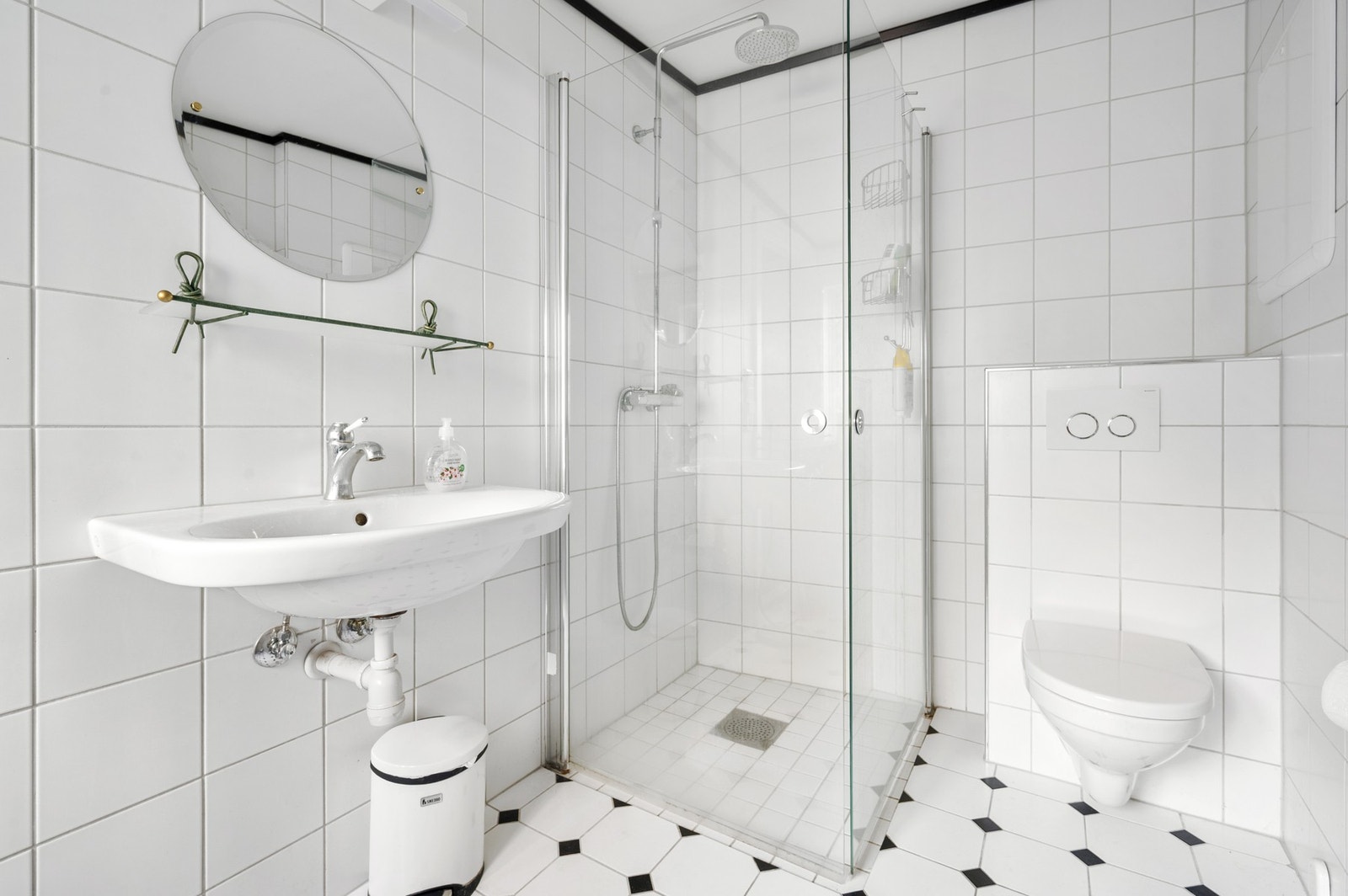 Lyst flislagt bad med eget dusjhjørne, toalett og servant. Galleribilde