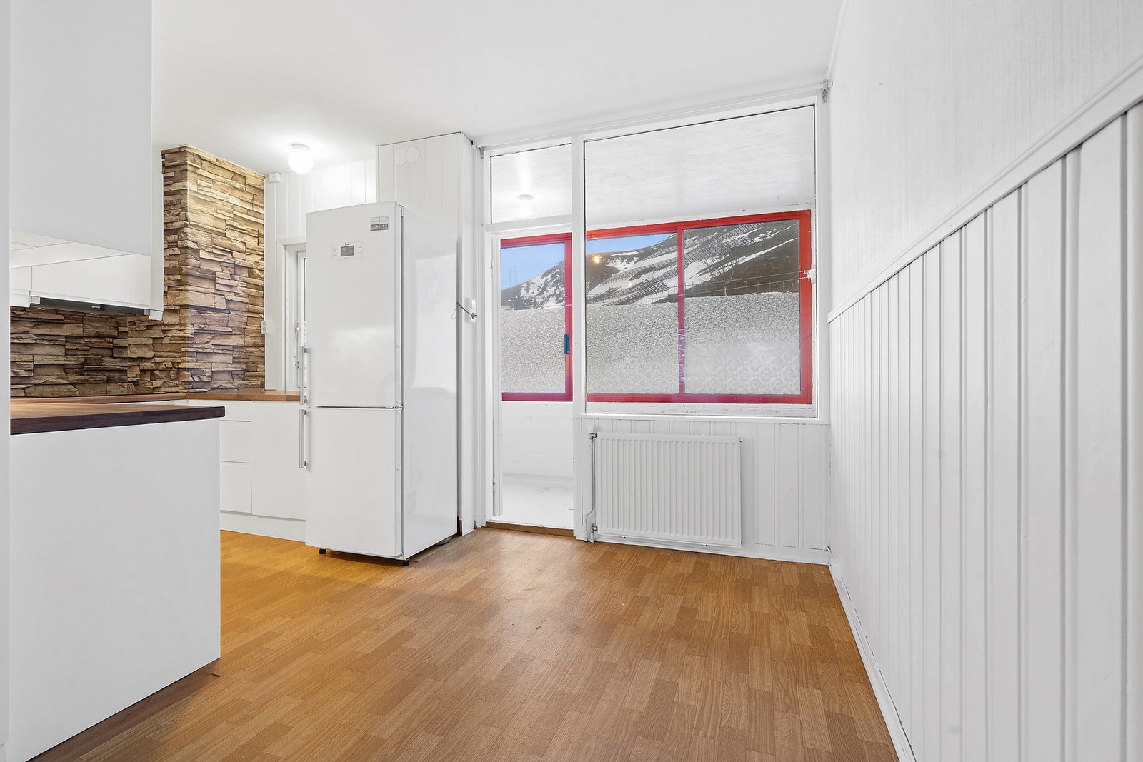 Kjøkken med spiseplass og utgang til innglasset balkong Galleribilde