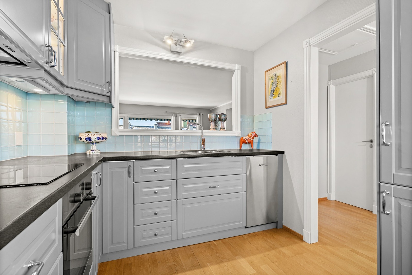 Det er flislagt på vegg over benkeplate, og montert benkebelysning under overskap. Galleribilde