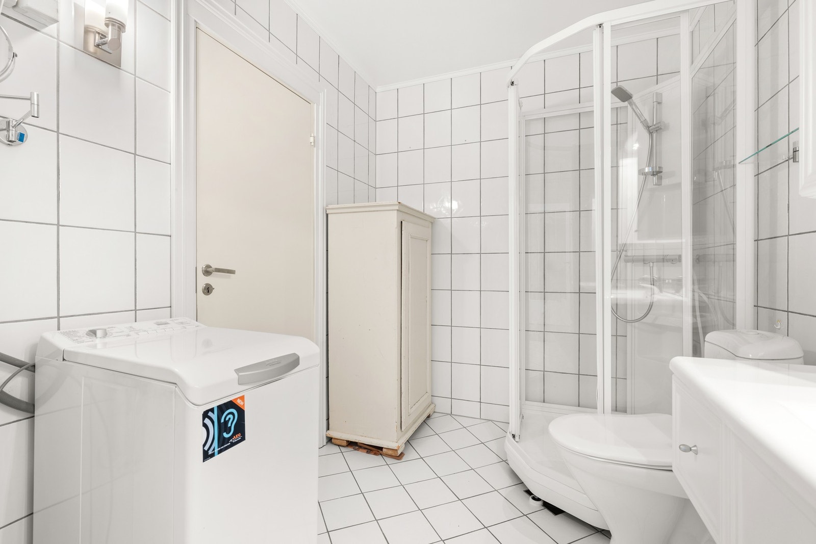 Badet har opplegg for vaskemaskin, dusjkabinett og servantinredning Galleribilde