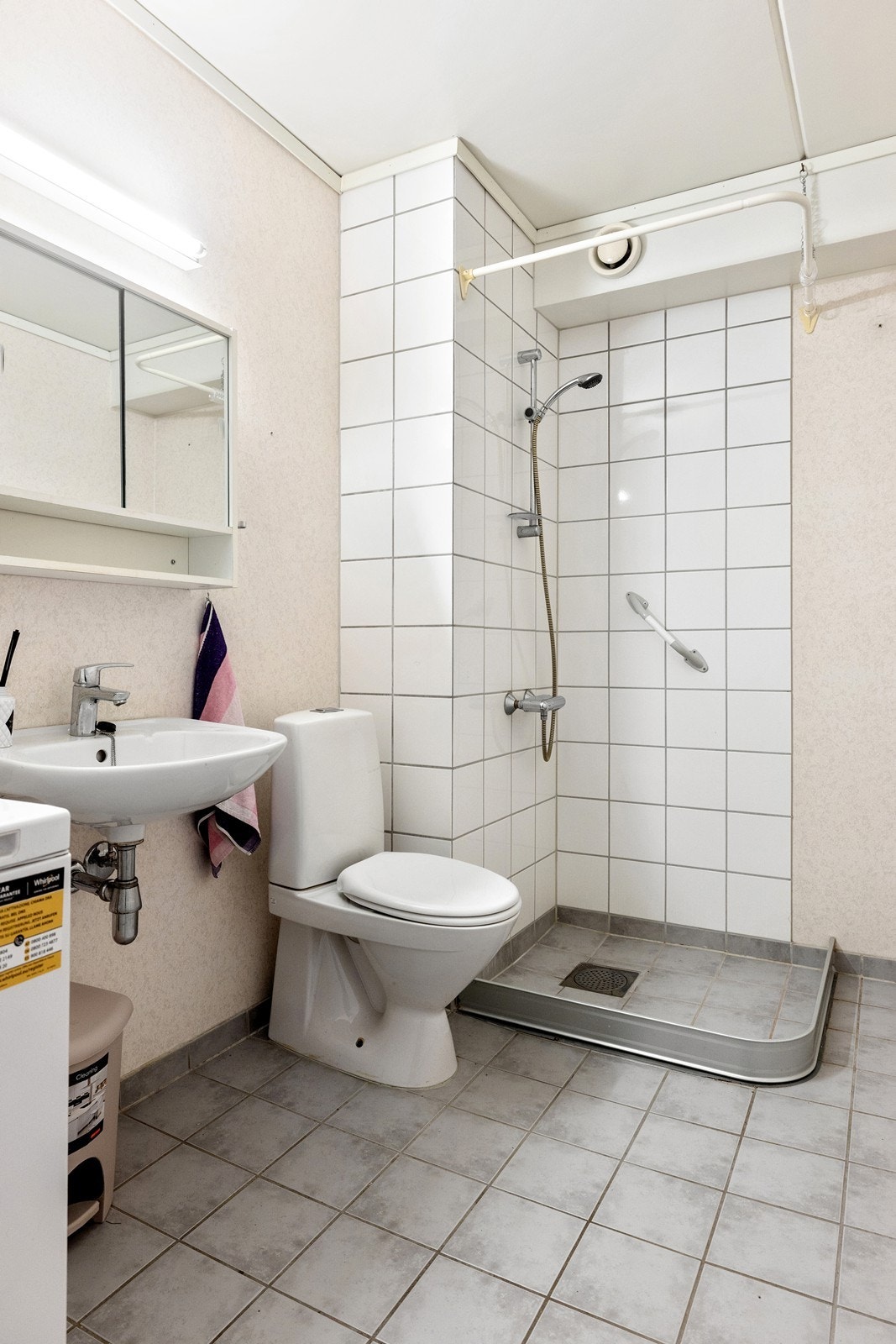 Badet inneholder servant, speilskap, toalett og dusjhjørne med hånddusj. Galleribilde