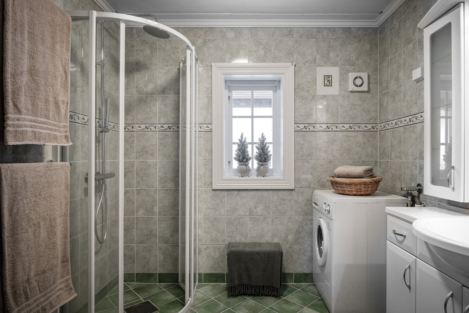 Det er et bad med dusj og opplegg for vaskemaskin. Galleribilde