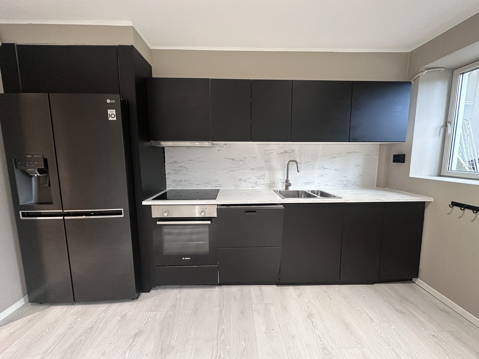 Kjøkkenet har svarte fronter og har godt med benk og skapplass Galleribilde