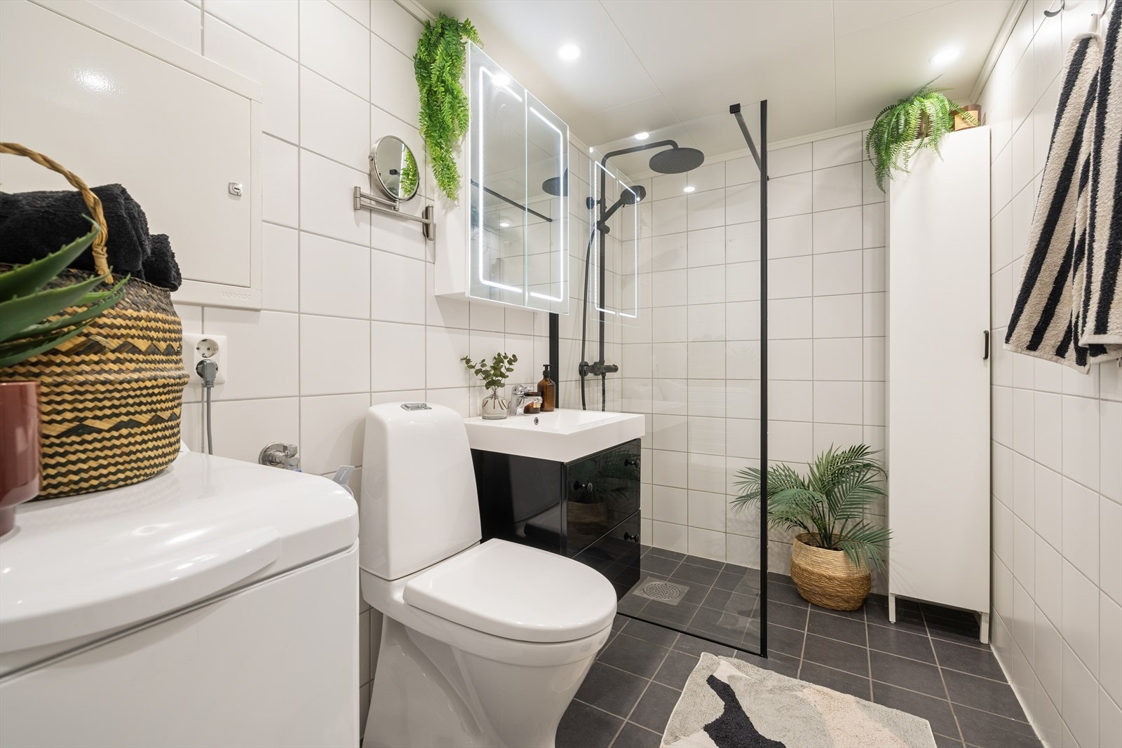 Pent bad med flislagte overflater, moderne uttrykk og ny dusj fra 2026. Galleribilde