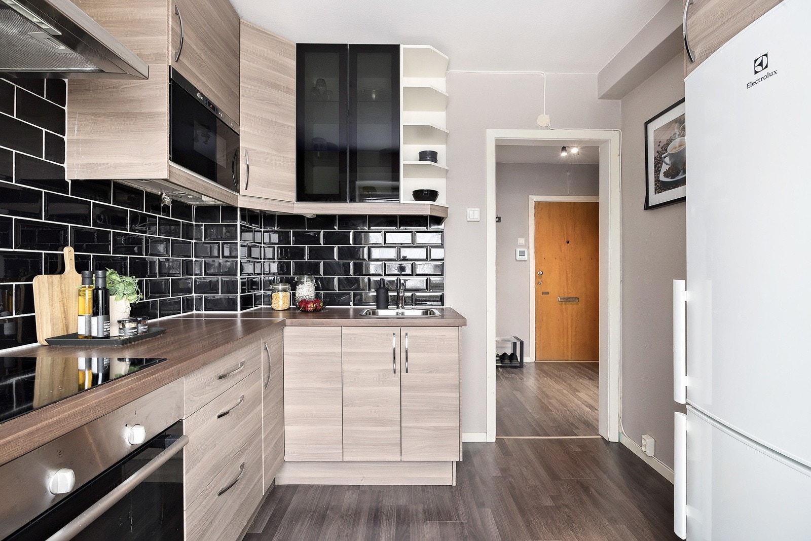 God skap- og benkeplass. Kjøkkenet er utstyrt med integrerte hvitevarer som koketopp, stekeovn og mikrobølgeovn Galleribilde