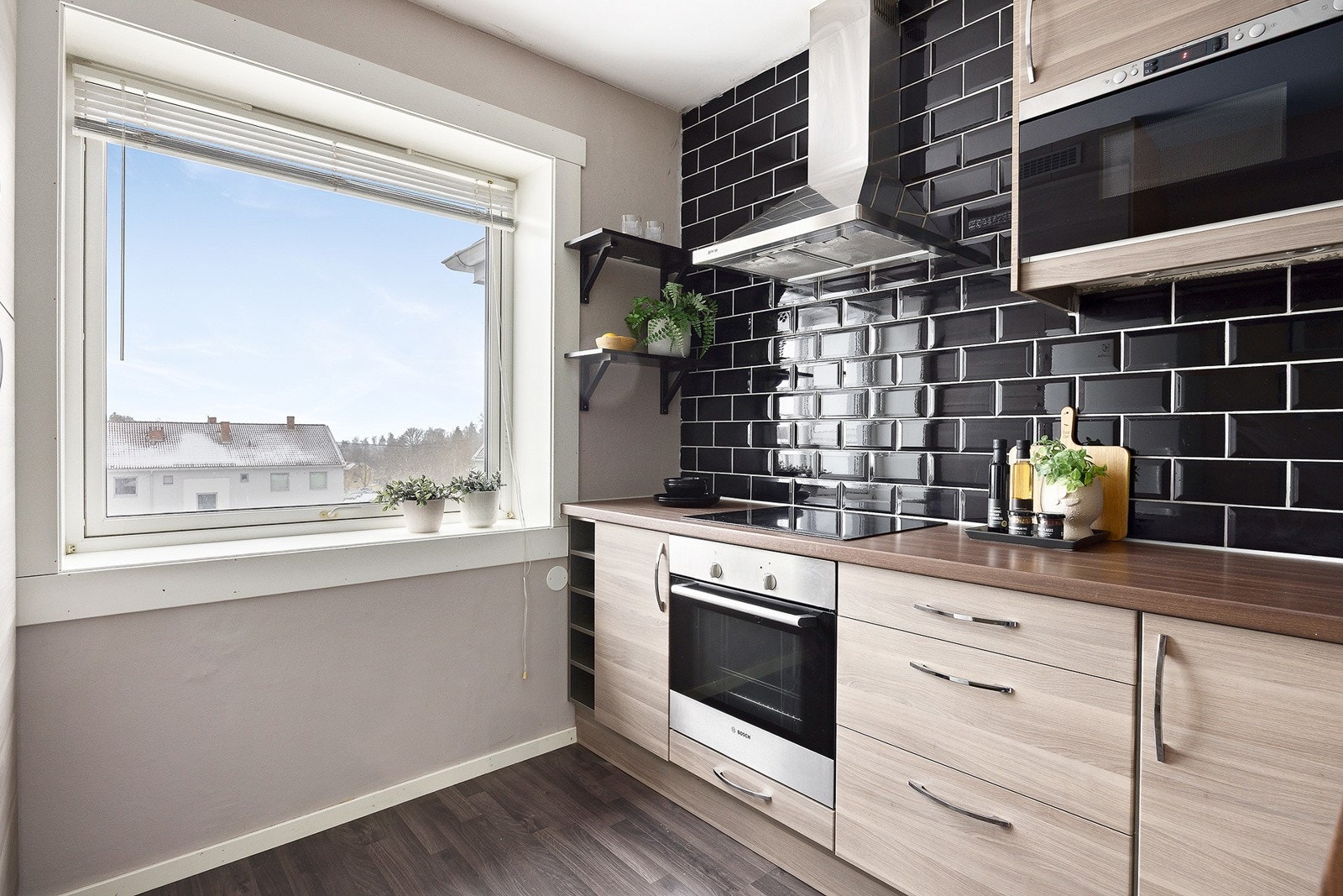 IKEA kjøkken med laminerte skapfronter, to skapfronter med sotet glass og laminat benkeplate med fliser på vegg. Galleribilde