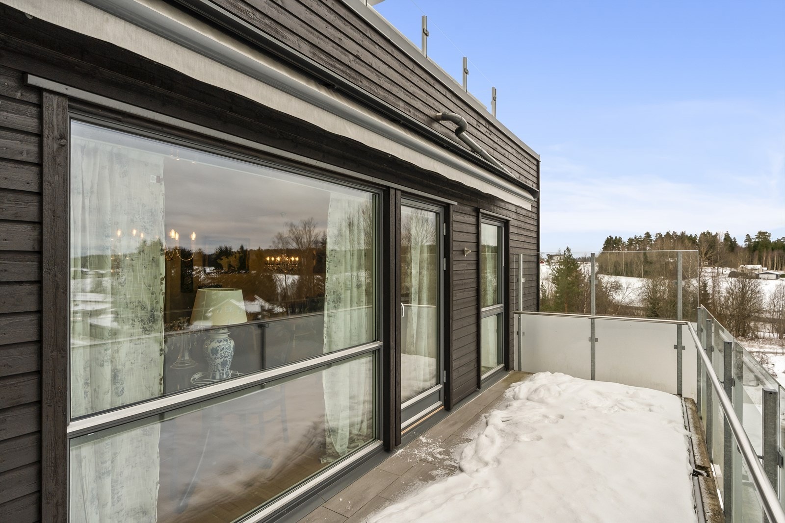 Vestvendt og solrik balkong med flislagt betongdekke og motorisert markise Galleribilde