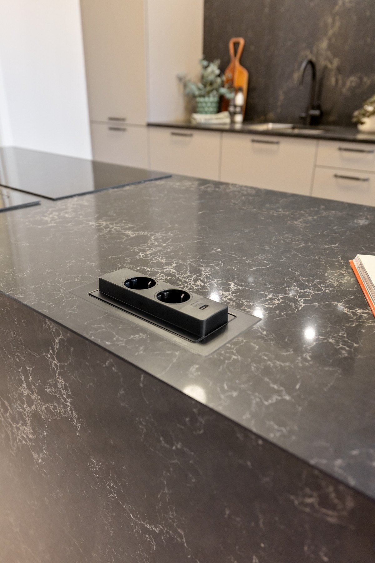 Innfelte stikkontakter i komposittplate på kjøkkenøy. Galleribilde