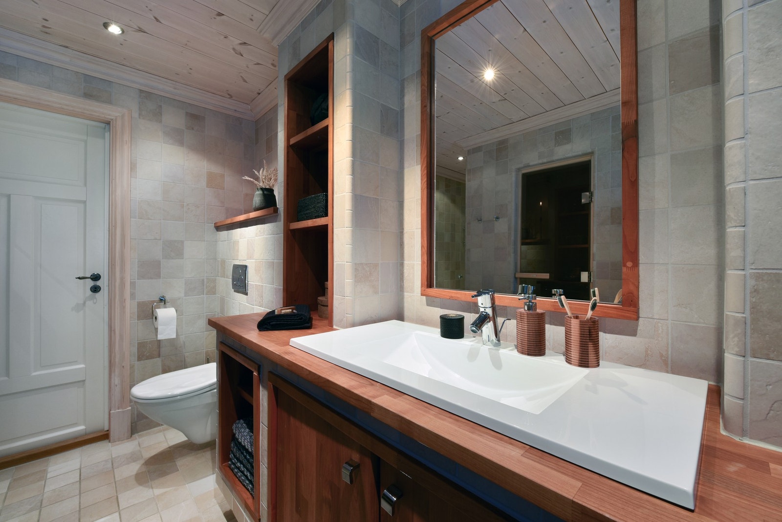 Badet er innredet med toalett, dusj, servant med innredning og en badstue. Galleribilde