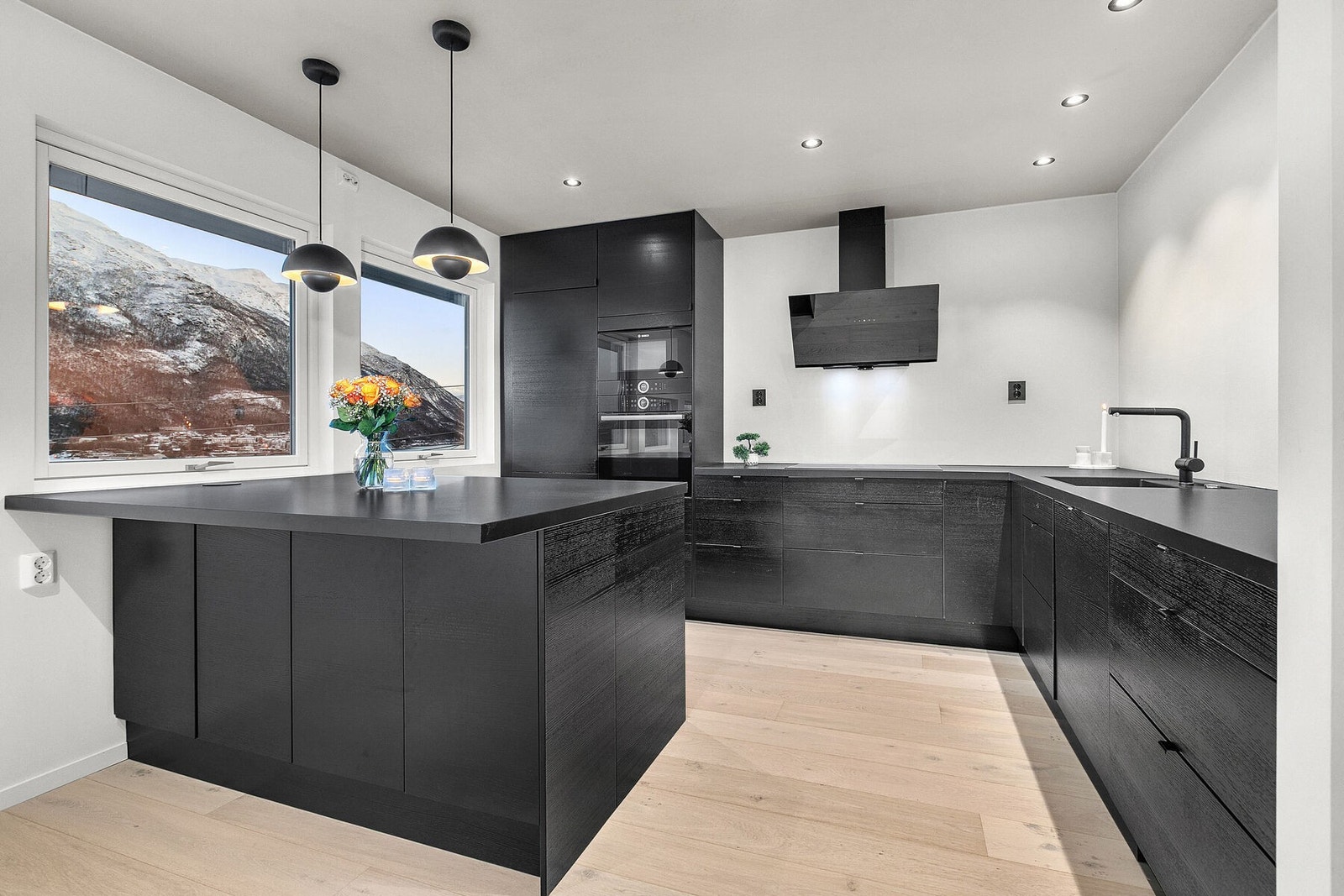 Lekkert kjøkken med integrerte hvitevarer, spotter i tak og fin utsikt Galleribilde