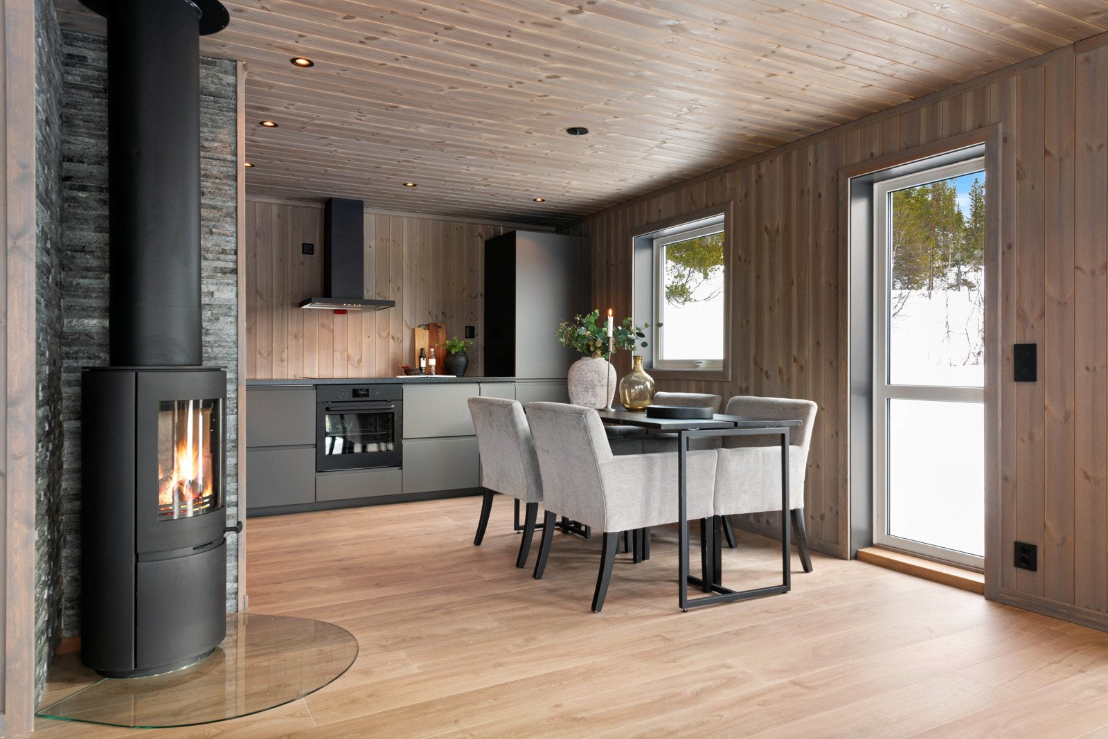 En moderne peisovn er plassert i hjørnet av rommet og har flammebilde som kan ses fra alle soner Galleribilde