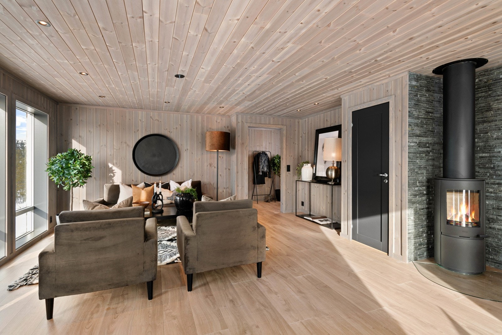 Stuen er holdt i samme stil som øvrige rom med pent, enstavs laminatgulv, kombinert med beisede panelvegger og matchende tak med downlights. Galleribilde