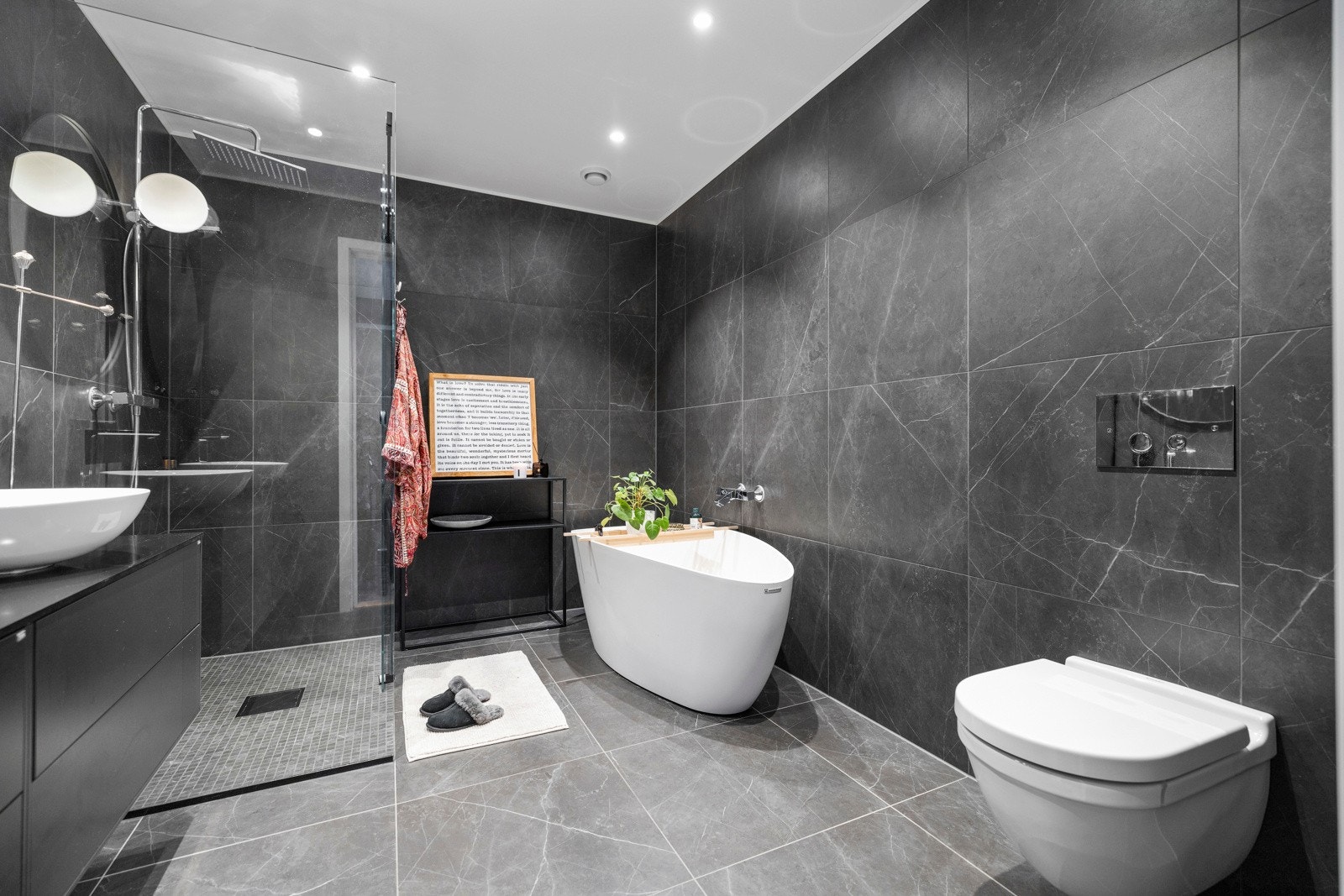 Boligens andre bad har store luksuriøse fliser og et flott designbadekar Galleribilde