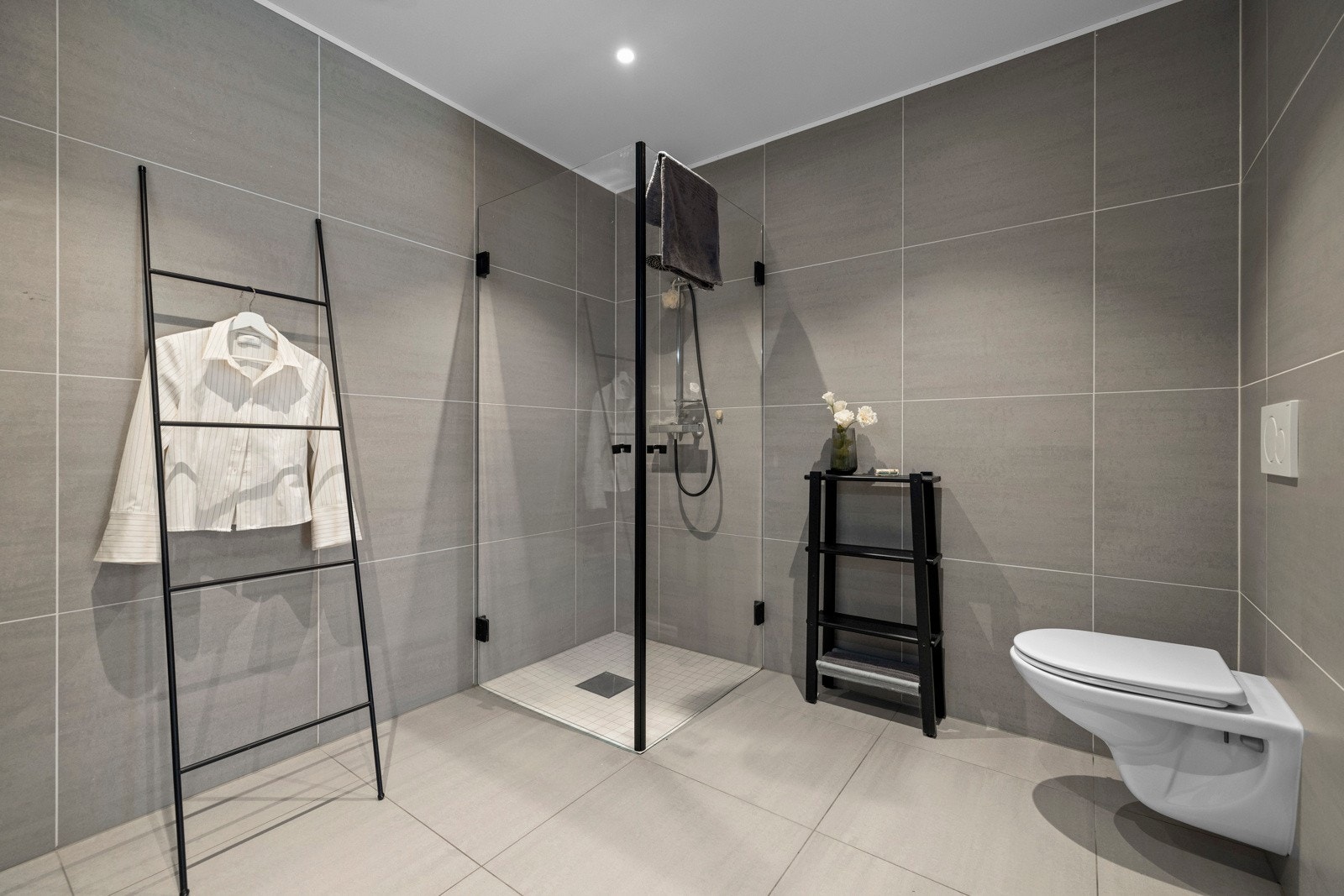 Badet i utleiedelen har store flotte fliser med en praktisk dusjsone og vegghengt toalett Galleribilde