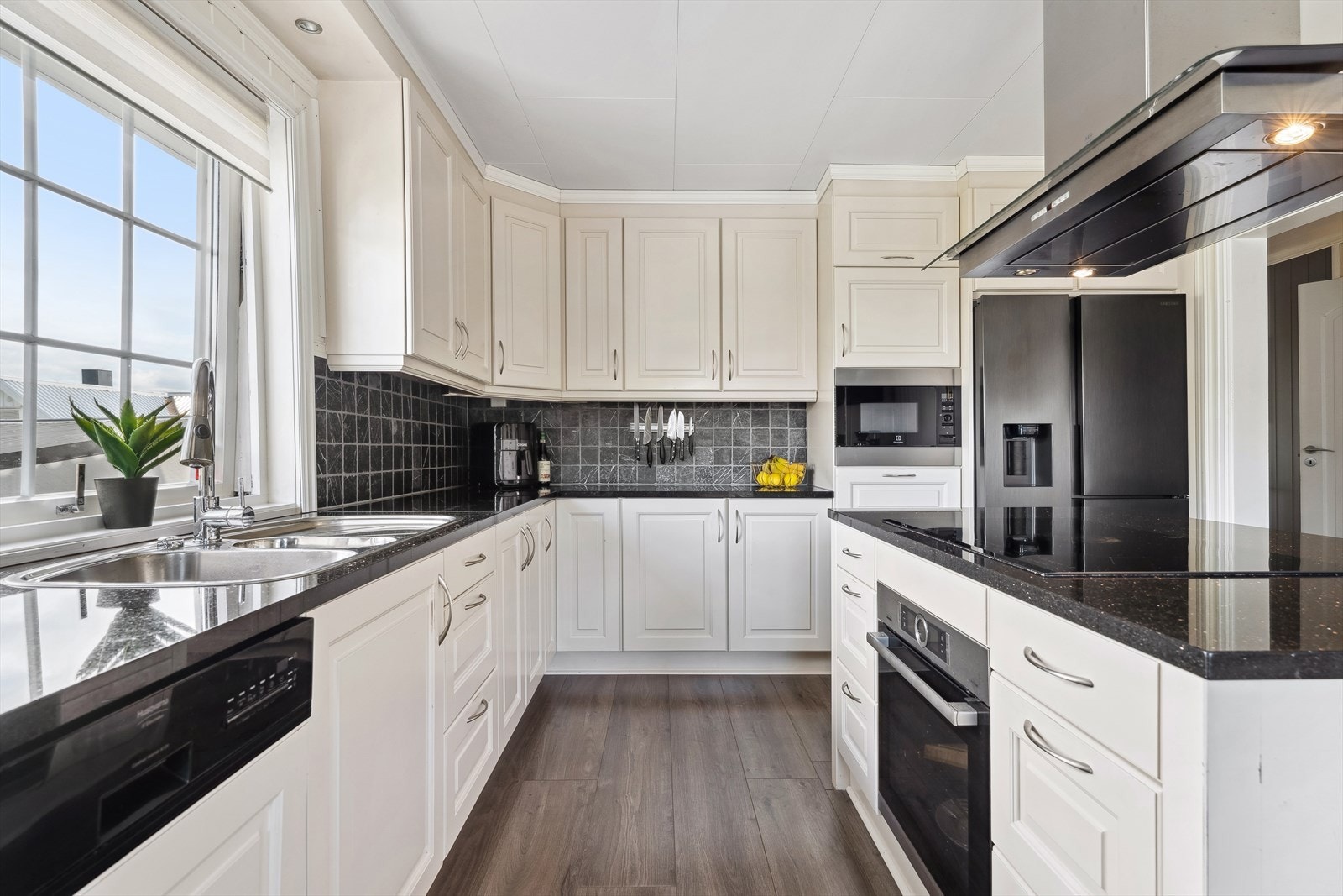 Kjøkkeninnredningen har profilerte fronter og en solid benkeplate i stein/kompositt. Galleribilde