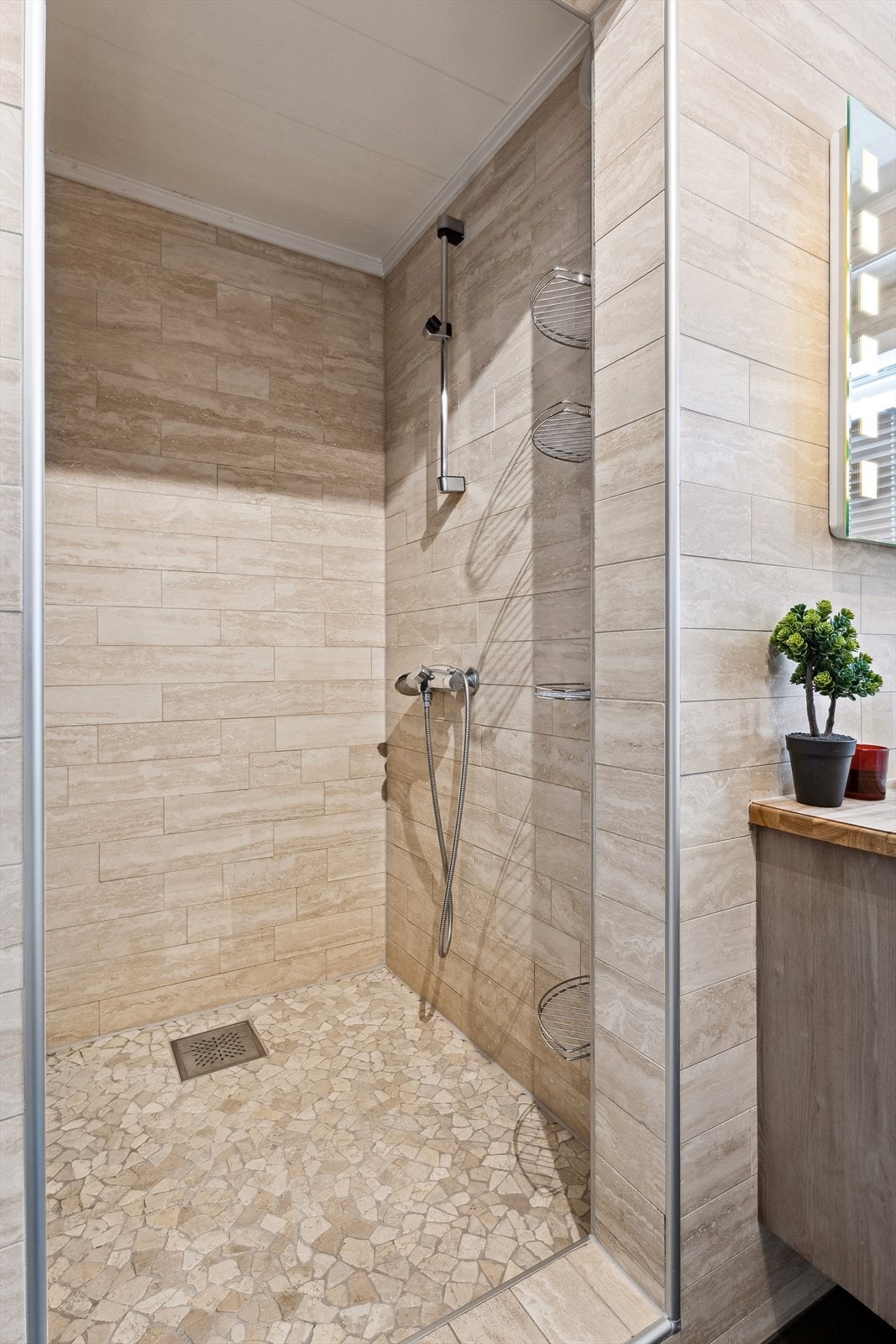 Rommet er utstyrt med en praktisk dusjnisje med mosaikkfliser på gulvet. Galleribilde