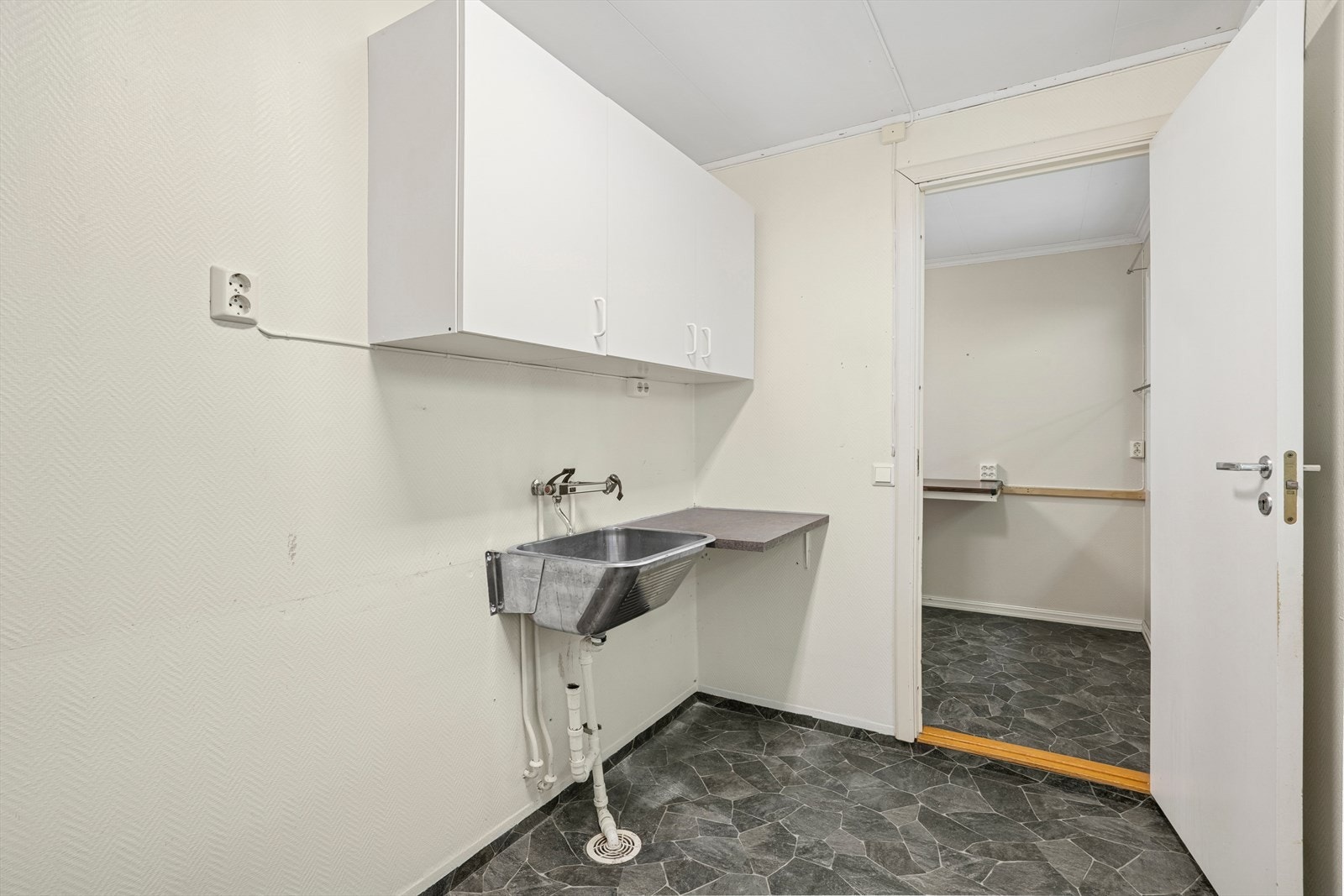 Enkelt innredet med utslagsvask, benk og overskap. Galleribilde